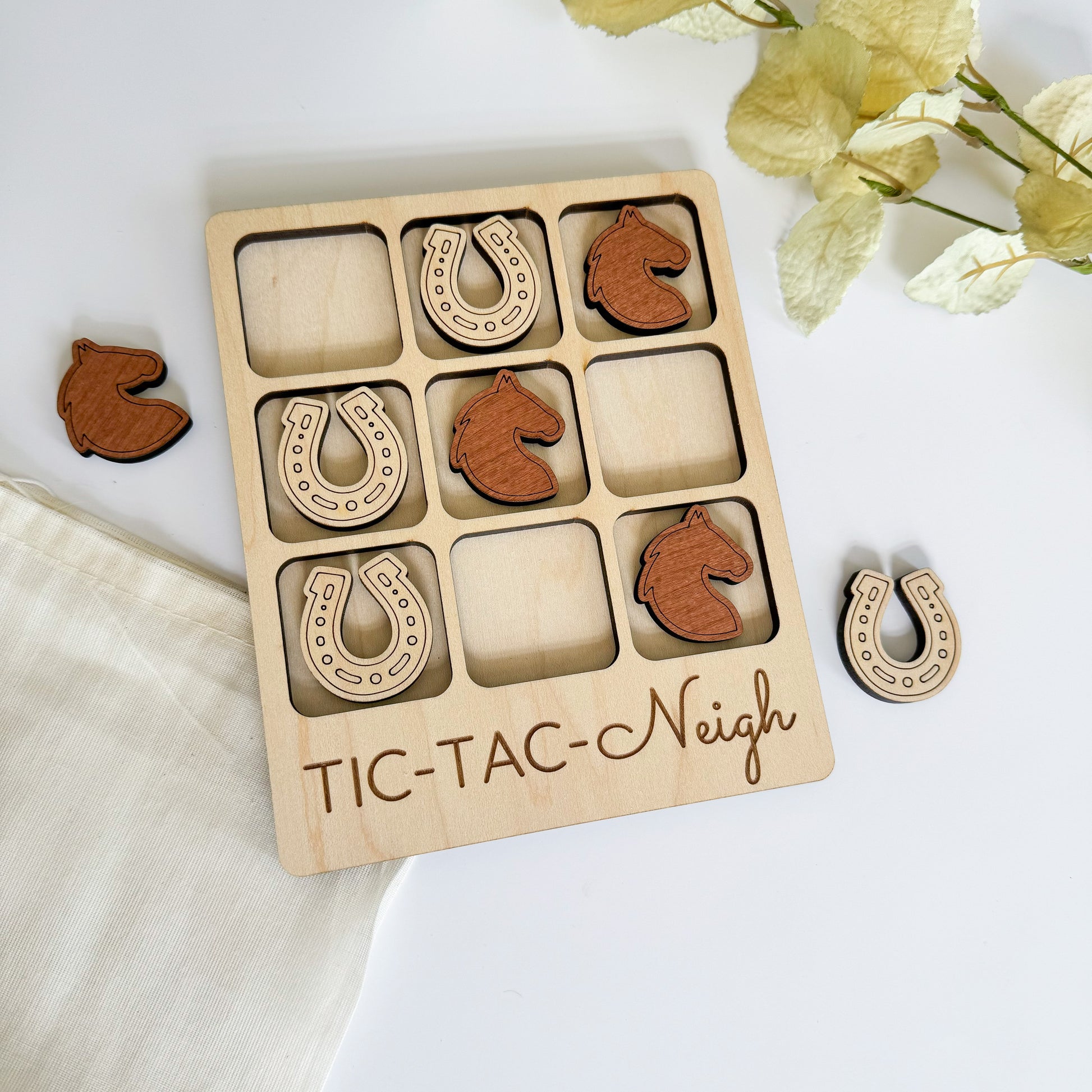 a wooden tictac - n - nigh board with a pair of horseshoe