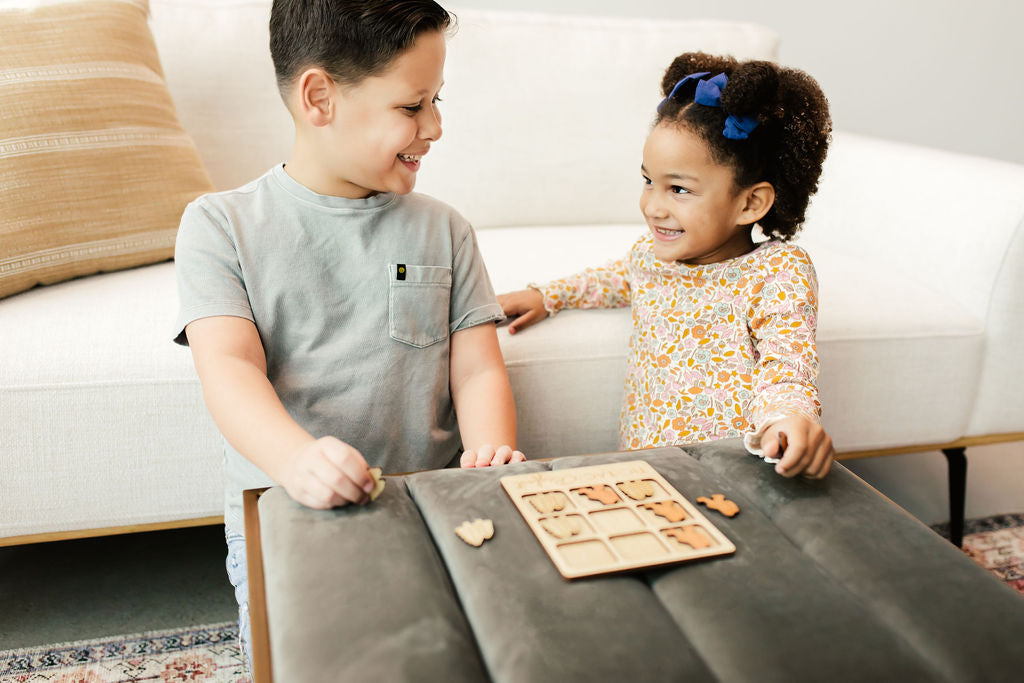 a boy and a girl playing a game on a coffee table