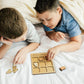 a boy and a boy laying in bed playing with a game