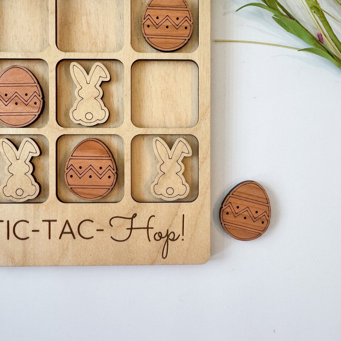 a wooden tic - tac - hop game with wooden easter eggs and bun