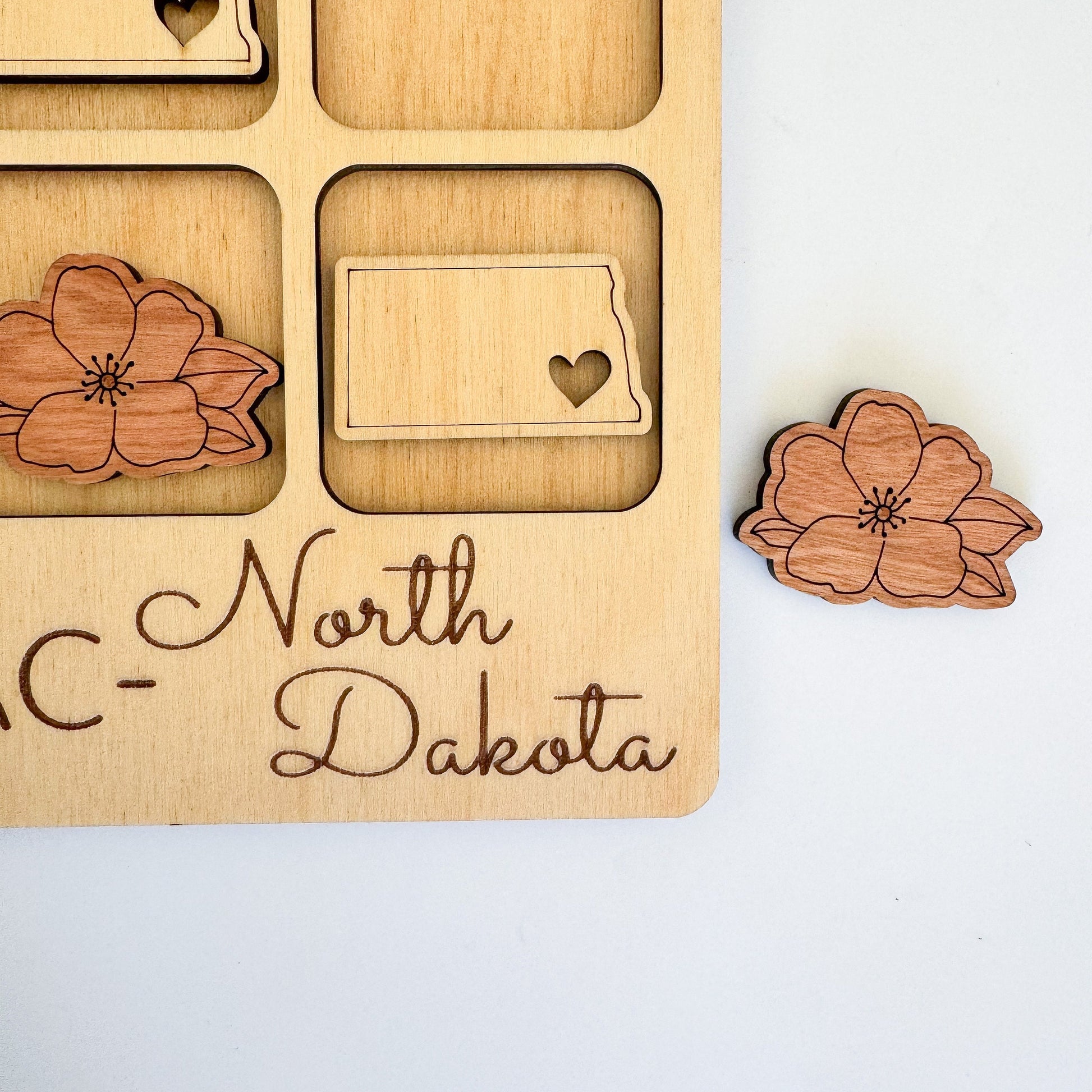 a wooden magnet with a flower and a state on it