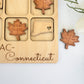 a wooden puzzle with a maple leaf, a map, and a heart