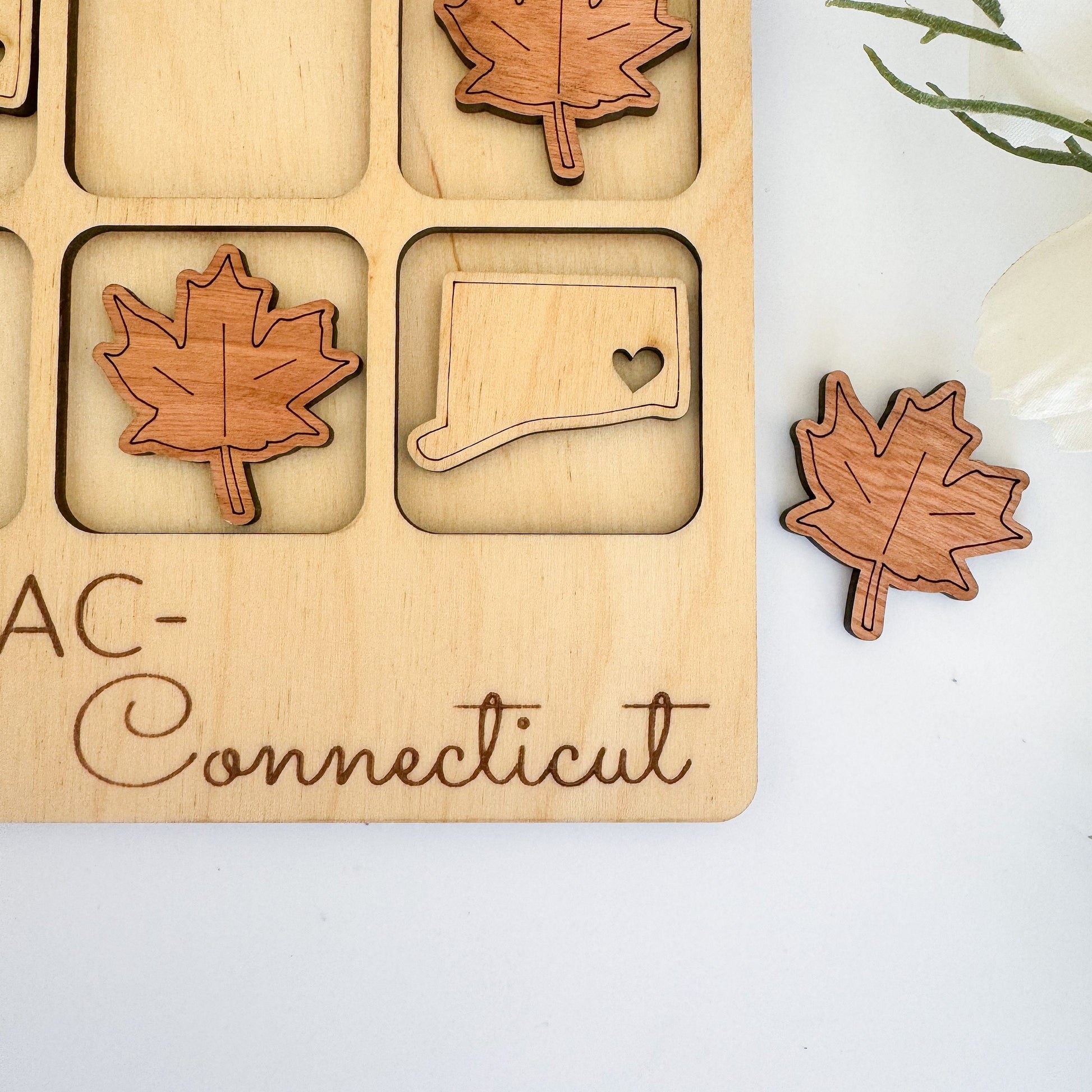 a wooden puzzle with a maple leaf, a map, and a heart