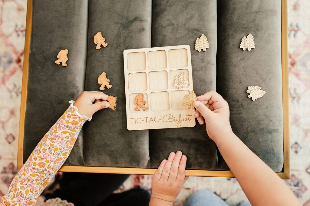 two children are playing with a wooden puzzle