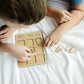 a young boy playing with a wooden puzzle