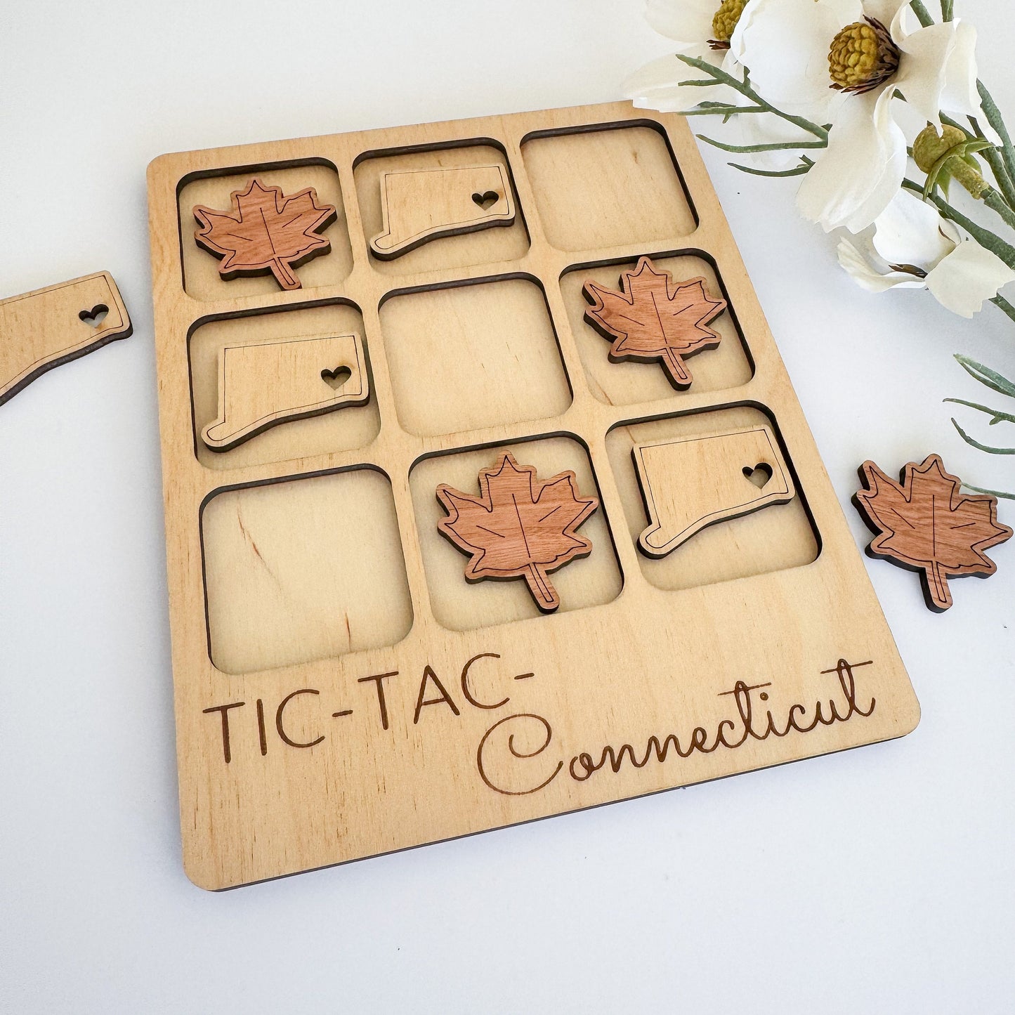 a wooden tray with a couple of maple leaves on it