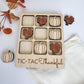 a wooden tray filled with pumpkins and cookies