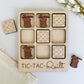 a wooden tic tac - tac quilt game with a couple of pieces