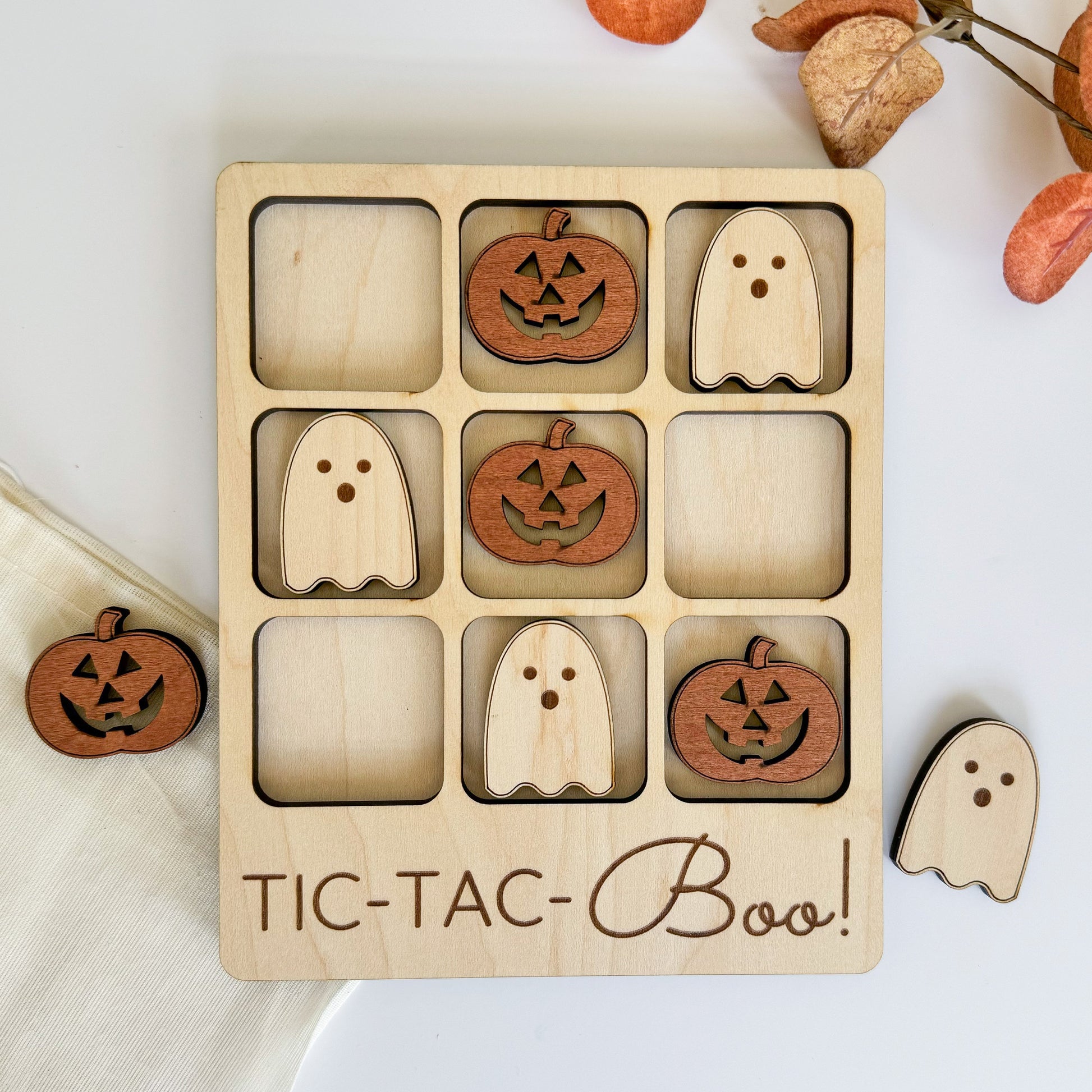 a wooden tic - tac - boo game with carved pumpkins and ghost