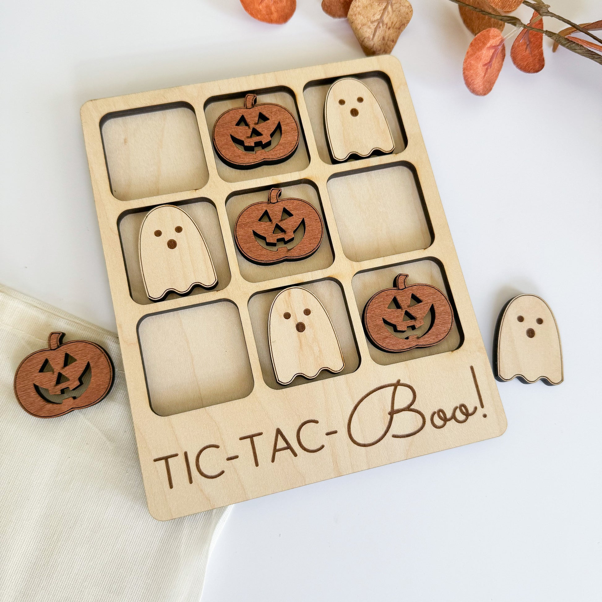 a wooden tic - tac - boo game with carved pumpkins and ghost