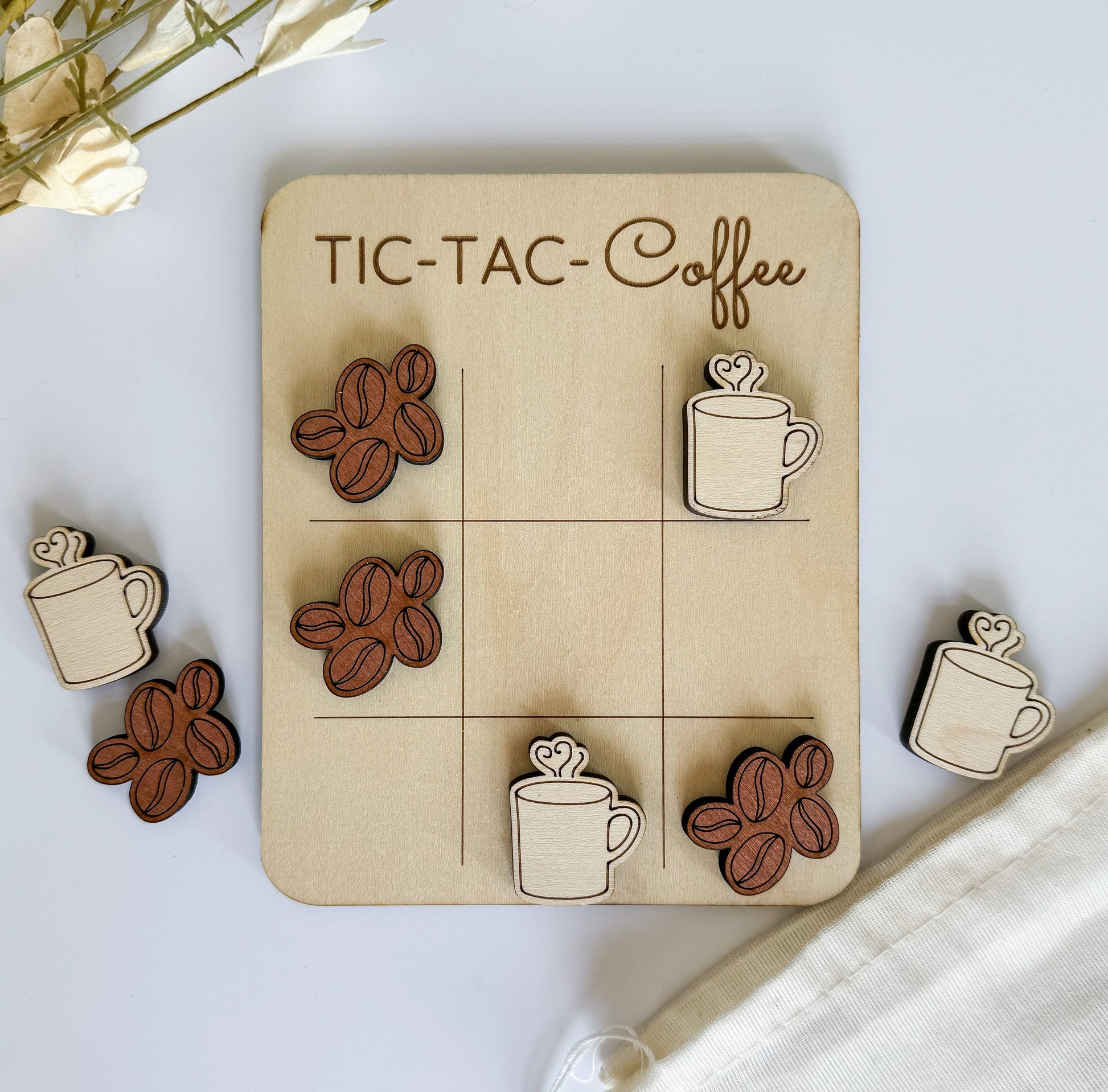 a wooden tic - tac - toe board with coffee cups and coffee beans