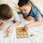 a boy and a boy laying in bed playing with a game